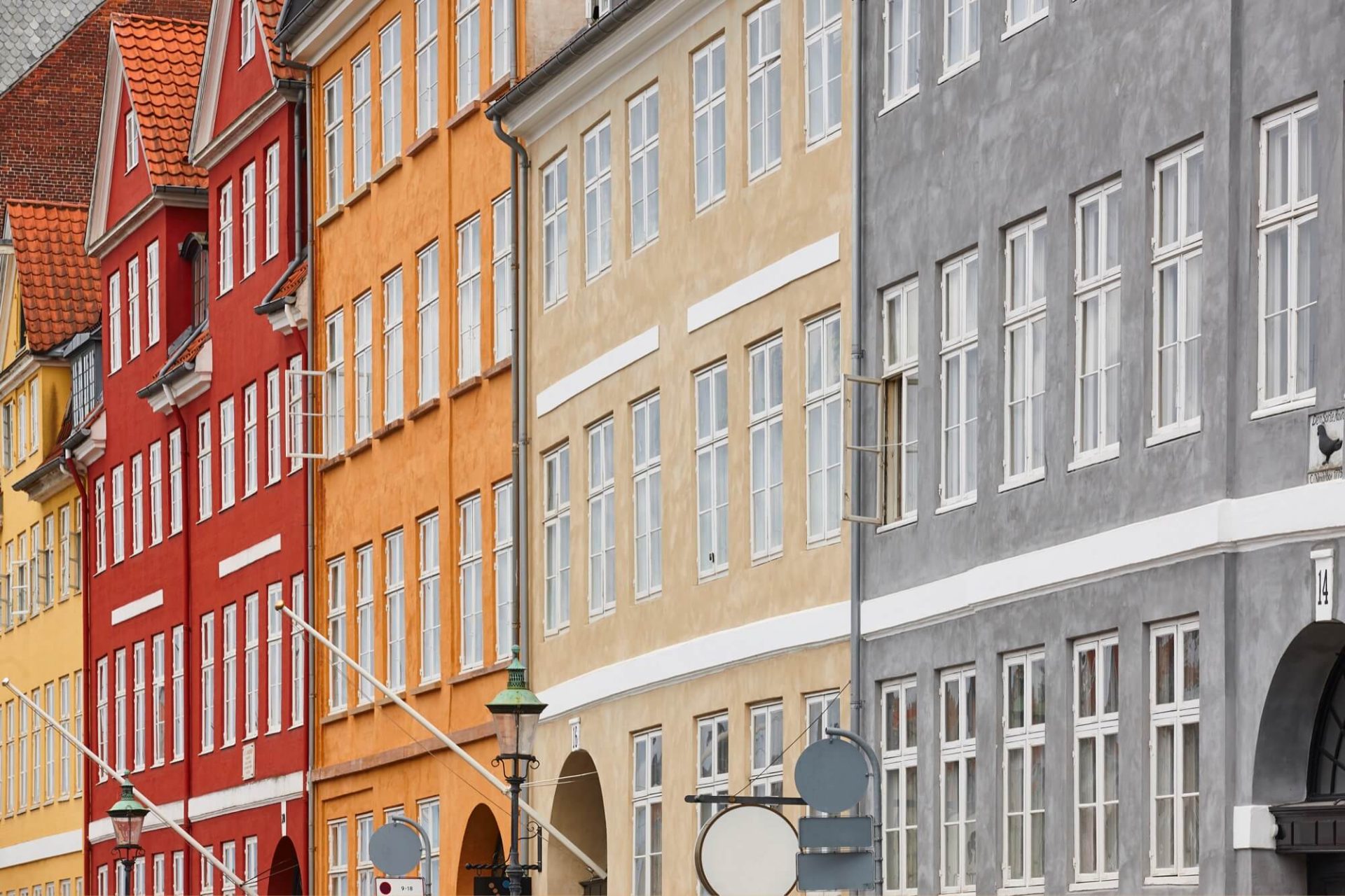 Stadshus i en rad som framhäver klassisk arkitektur med sina färgglada fasader i rött, gult och grått