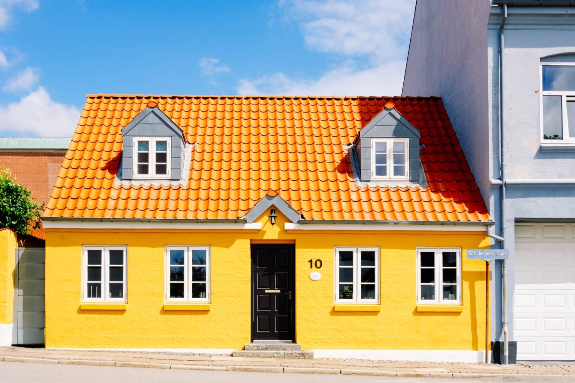 En bostad med en iögonfallande kombination av gult, orange och svart, belägen i en urban miljö